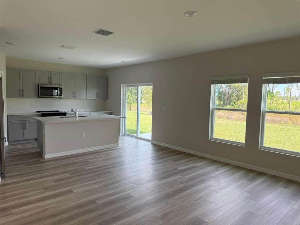 Empty room, Interior, Kitchen, Recessed Lighting, Stainless Steel Appliances, Wood Texture Flooring