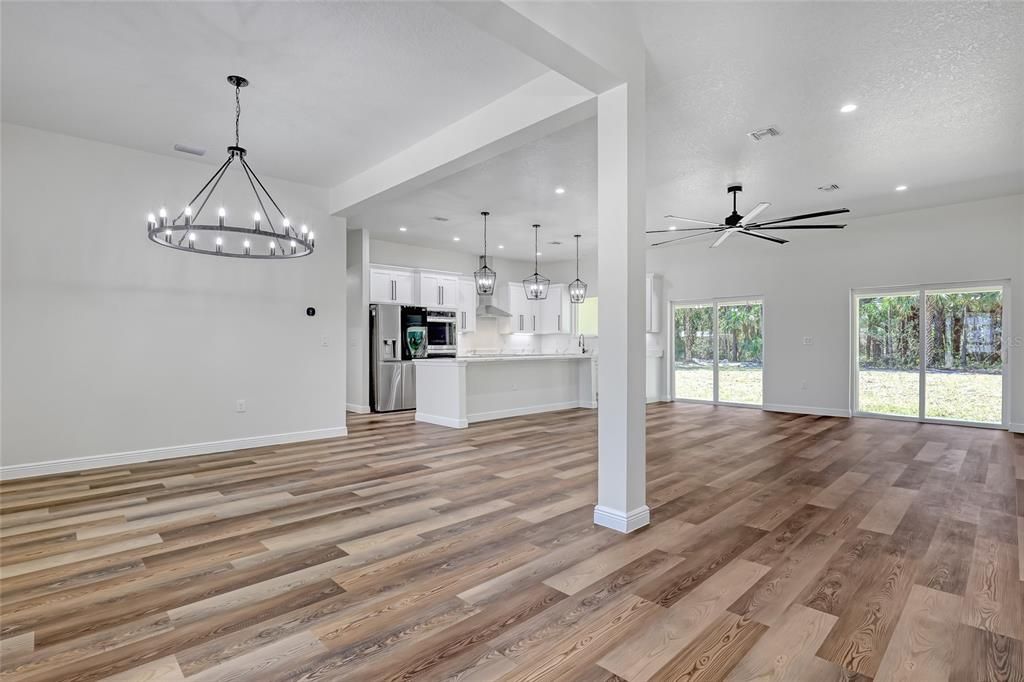 Chandelier, Empty room, Interior, Kitchen, Pendant Lights, Recessed Lighting, Stainless Steel Appliances, Wood Texture Flooring