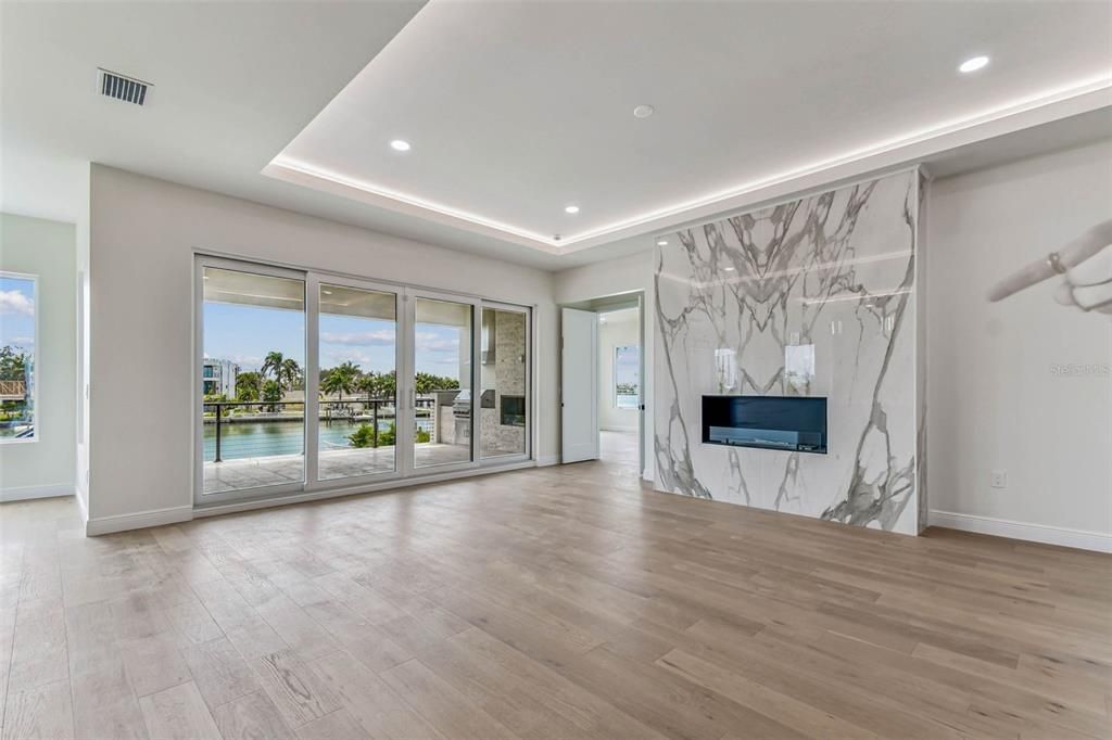 Empty room, Fireplace, Interior, Marble Walls, Recessed Lighting, Water, Wood Texture Flooring