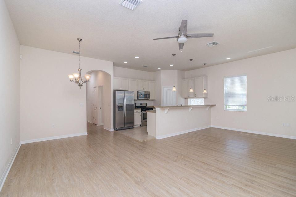Chandelier, Empty room, Interior, Kitchen, Pendant Lights, Recessed Lighting, Stainless Steel Appliances, Wood Texture Flooring