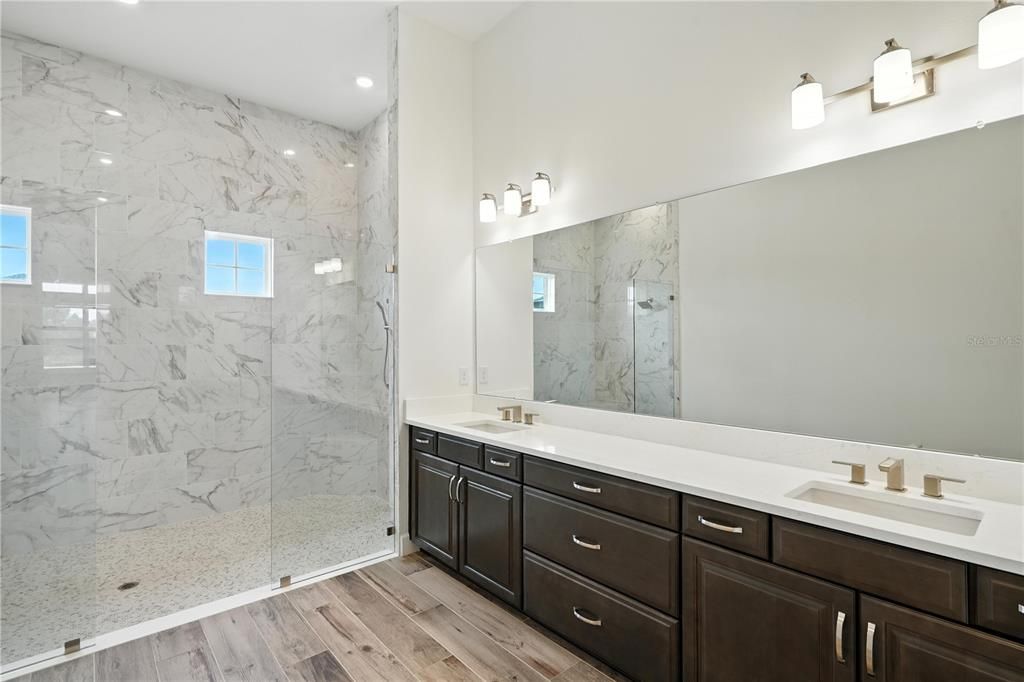 Bathroom, Dual Sink Vanities, Glass Shower, Interior, Marble Walls, Recessed Lighting, Wood Texture Flooring