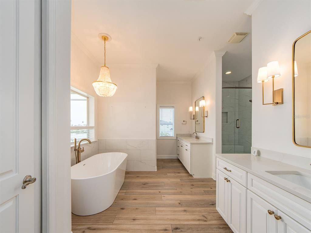 Bathroom, Chandelier, Dual Sink Vanities, Free Standing Baths, Glass Shower, Interior, Pendant Lights, Recessed Lighting, Wood Texture Flooring
