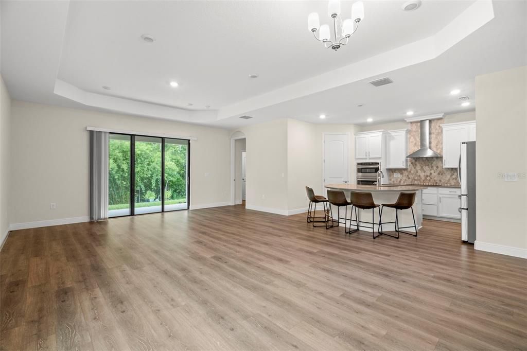 Empty room, Interior, Kitchen, Pendant Lights, Recessed Lighting, Stainless Steel Appliances, Wood Texture Flooring