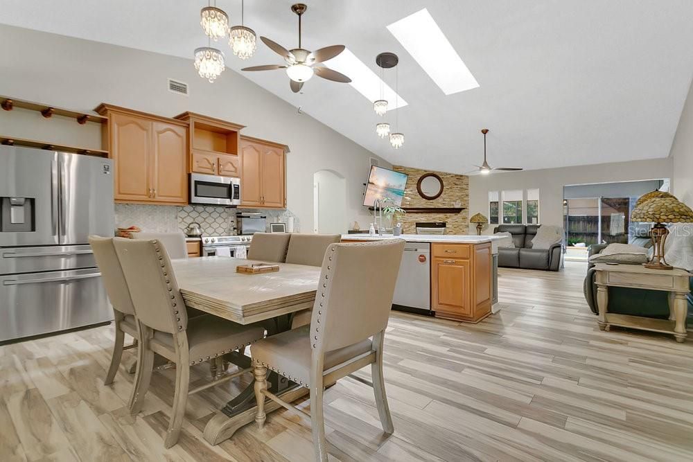 Chandelier, Dining room, Fireplace, Interior, Kitchen, Living room, Pendant Lights, Stainless Steel Appliances, Stone Walls, Wood Texture Flooring