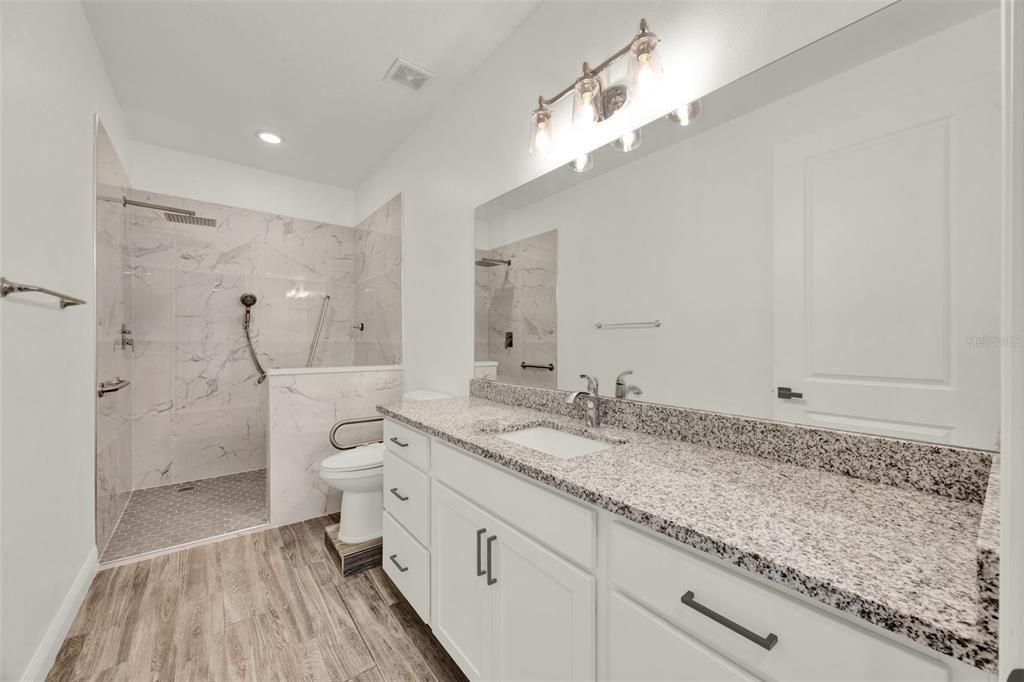 Bathroom, Dual Sink Vanities, Glass Shower, Interior, Marble Walls, Recessed Lighting, Wood Texture Flooring