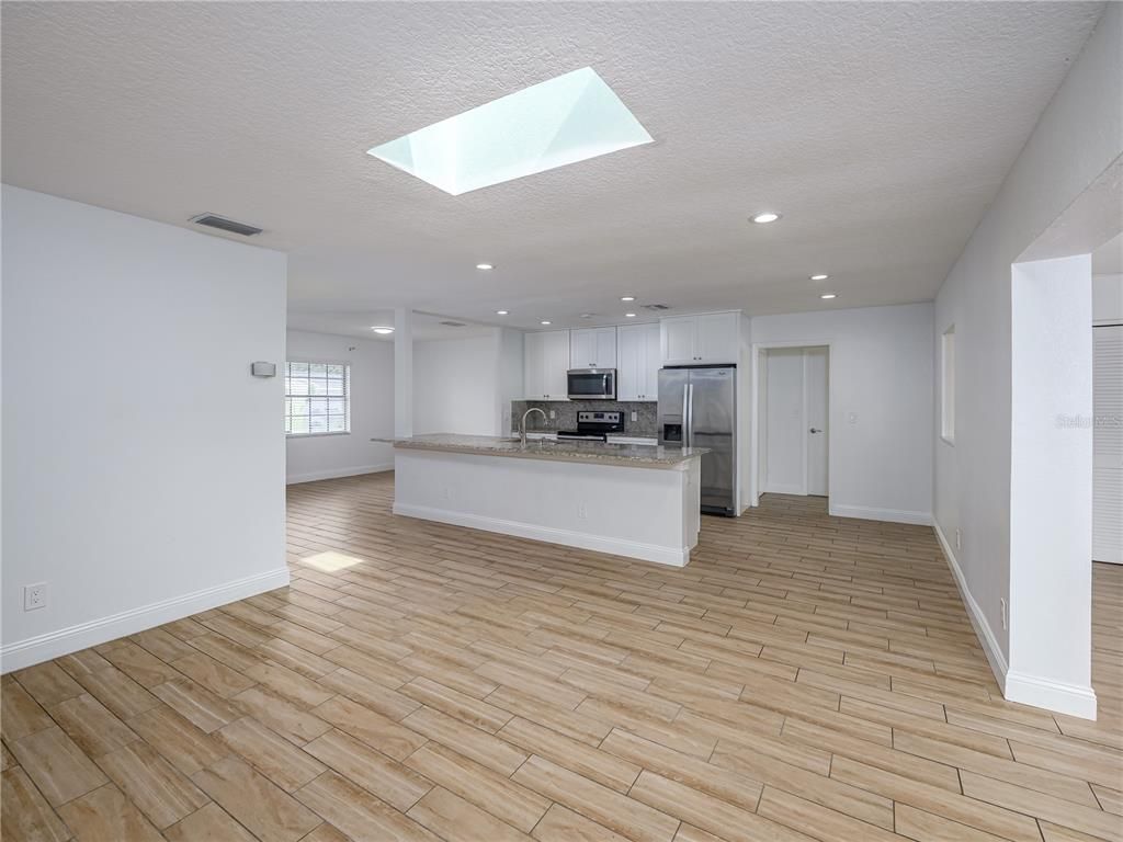 Empty room, Interior, Kitchen, Recessed Lighting, Stainless Steel Appliances, Wood Texture Flooring