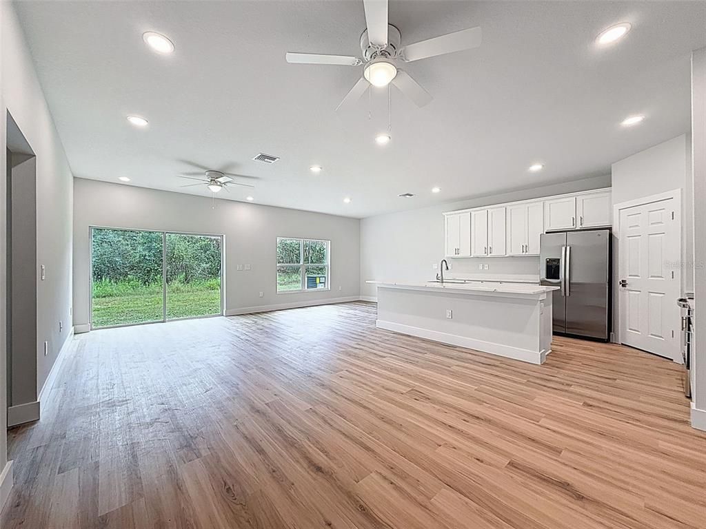 Empty room, Interior, Kitchen, Recessed Lighting, Stainless Steel Appliances, Wood Texture Flooring