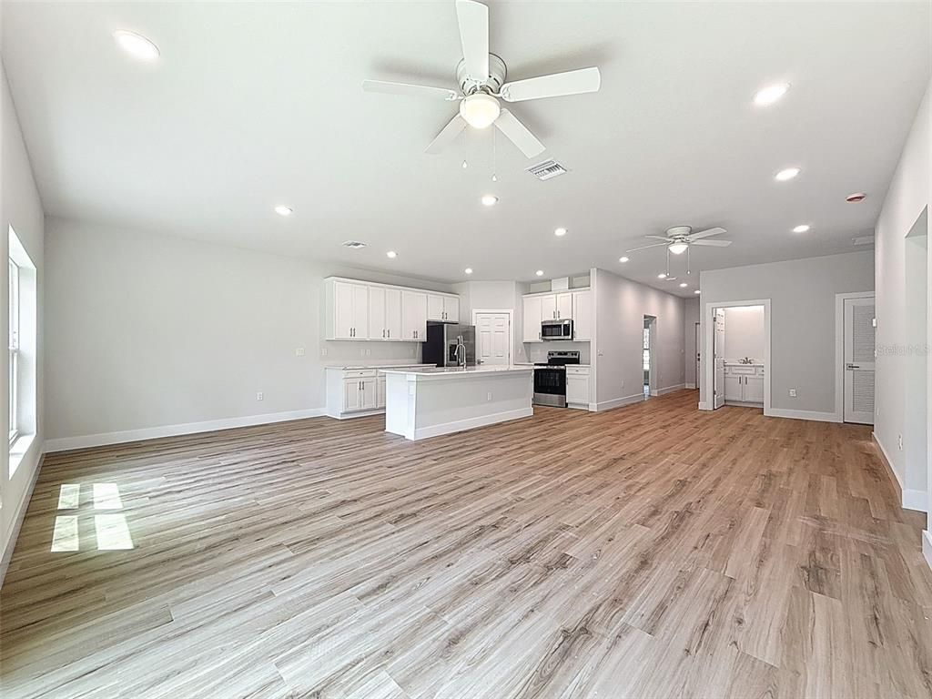 Empty room, Interior, Kitchen, Recessed Lighting, Stainless Steel Appliances, Wood Texture Flooring
