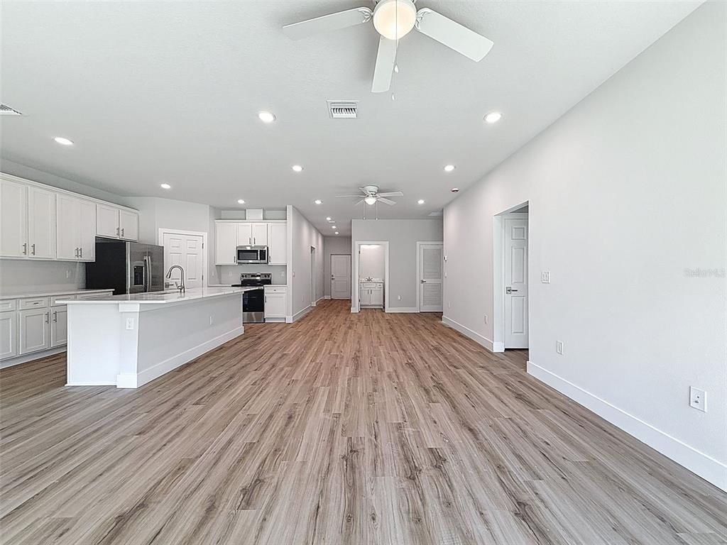 Empty room, Interior, Kitchen, Recessed Lighting, Stainless Steel Appliances, Wood Texture Flooring