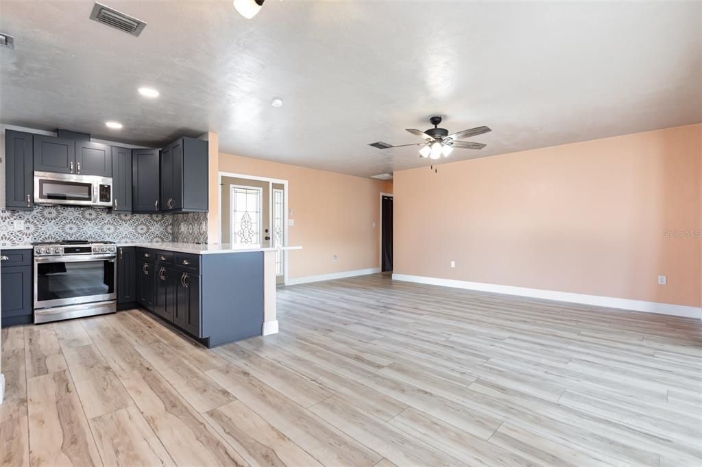 Empty room, Interior, Kitchen, Recessed Lighting, Stainless Steel Appliances, Wood Texture Flooring