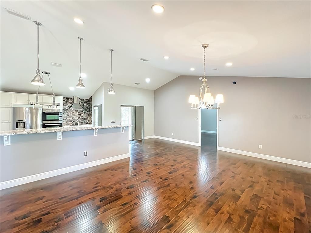 Chandelier, Empty room, Interior, Kitchen, Pendant Lights, Recessed Lighting, Stainless Steel Appliances, Wood Texture Flooring