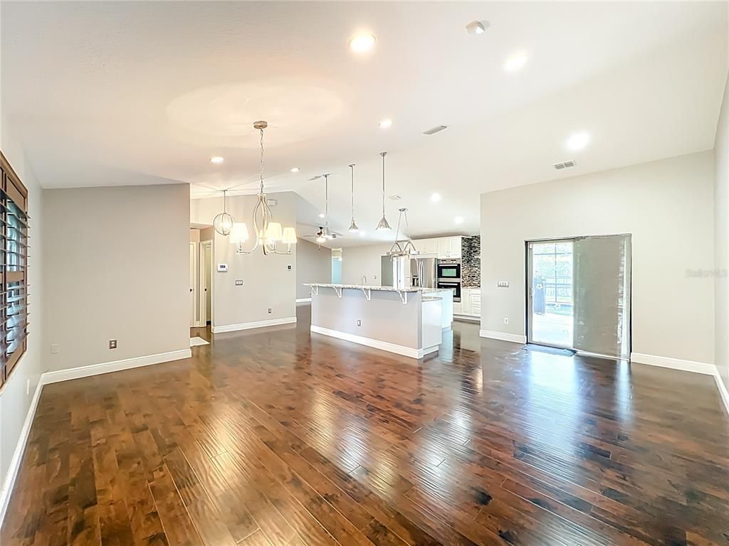 Chandelier, Empty room, Interior, Kitchen, Pendant Lights, Recessed Lighting, Stainless Steel Appliances, Wood Texture Flooring