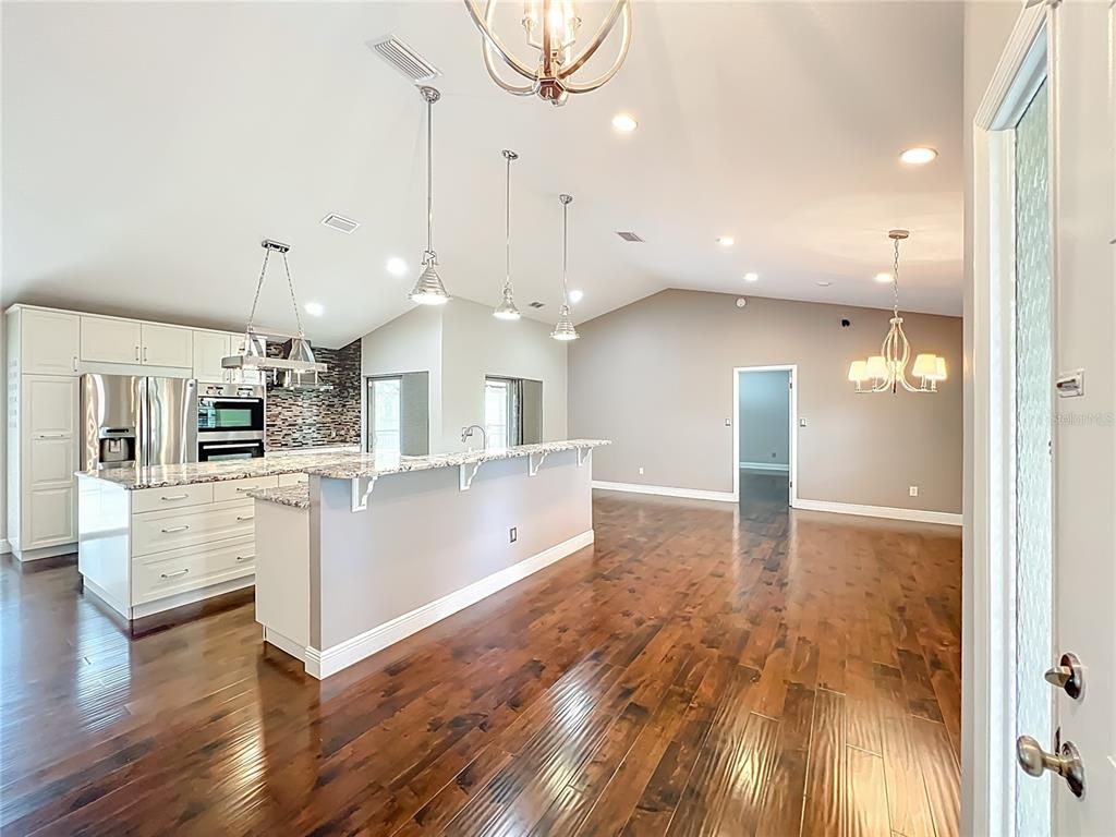 Chandelier, Empty room, Interior, Kitchen, Pendant Lights, Recessed Lighting, Stainless Steel Appliances, Wood Texture Flooring