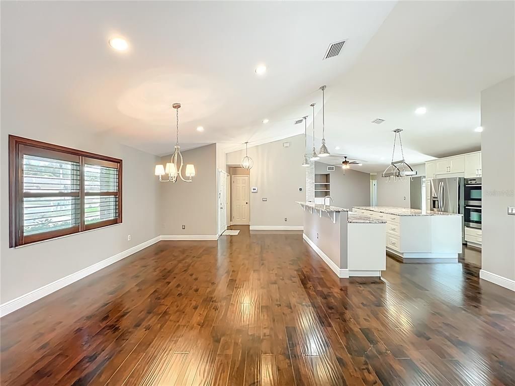 Chandelier, Empty room, Interior, Kitchen, Pendant Lights, Recessed Lighting, Stainless Steel Appliances, Wood Texture Flooring