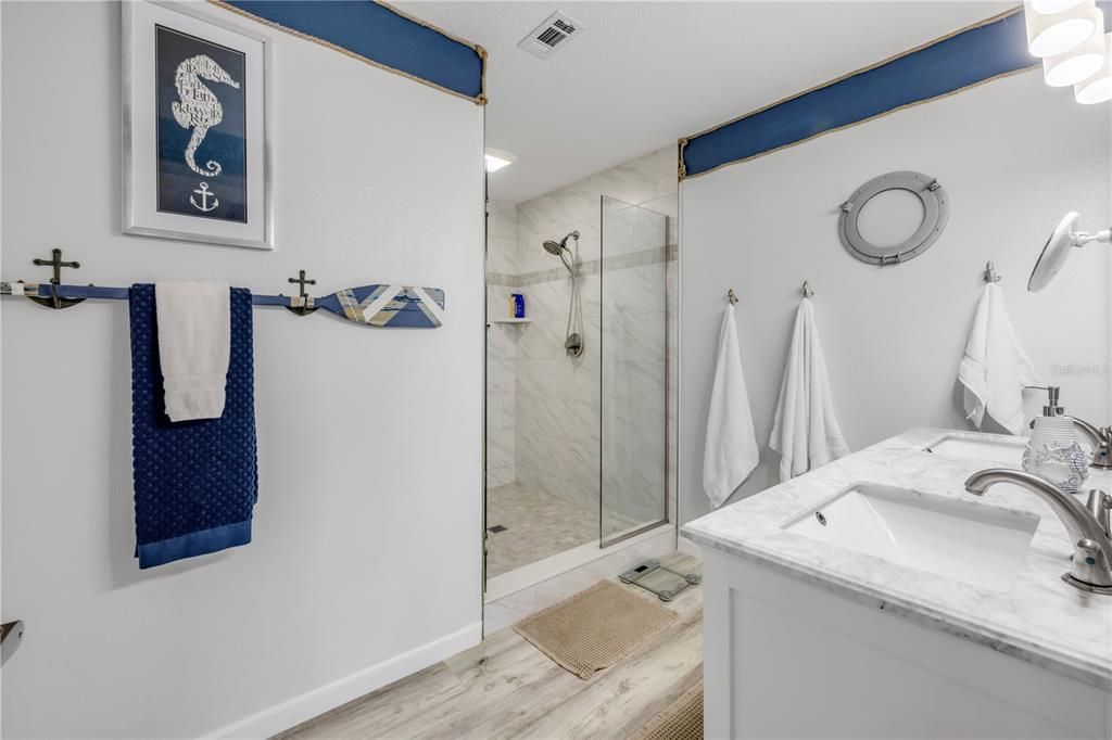 Bathroom, Dual Sink Vanities, Glass Shower, Interior, Marble Walls, Wood Texture Flooring