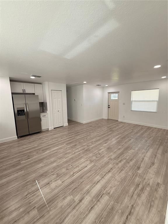 Empty room, Interior, Kitchen, Recessed Lighting, Stainless Steel Appliances, Wood Texture Flooring