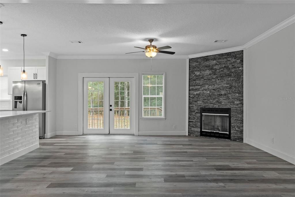 Empty room, Fireplace, Interior, Kitchen, Pendant Lights, Recessed Lighting, Stainless Steel Appliances, Stone Walls, Wood Texture Flooring