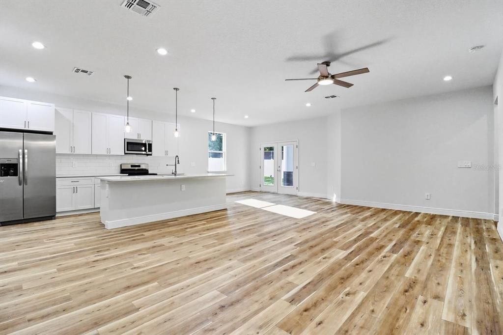 Empty room, Interior, Kitchen, Pendant Lights, Recessed Lighting, Stainless Steel Appliances, Wood Texture Flooring