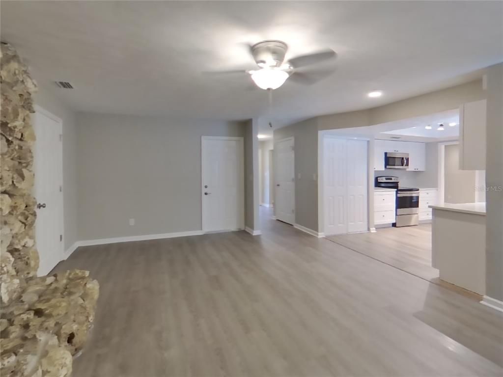 Empty room, Interior, Kitchen, Recessed Lighting, Stainless Steel Appliances, Wood Texture Flooring