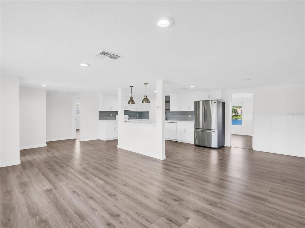 Empty room, Interior, Kitchen, Pendant Lights, Recessed Lighting, Stainless Steel Appliances, Wood Texture Flooring