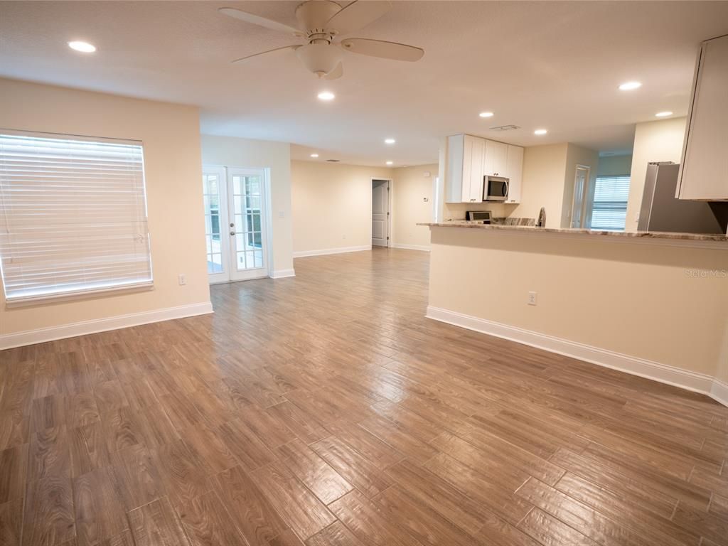 Empty room, Interior, Kitchen, Recessed Lighting, Stainless Steel Appliances, Wood Texture Flooring