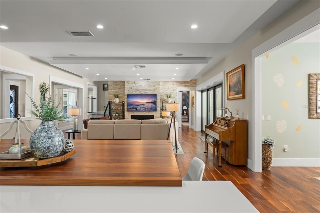 Dining room, Fireplace, Interior, Living room, Piano, Recessed Lighting, Stone Walls, Wood Texture Flooring