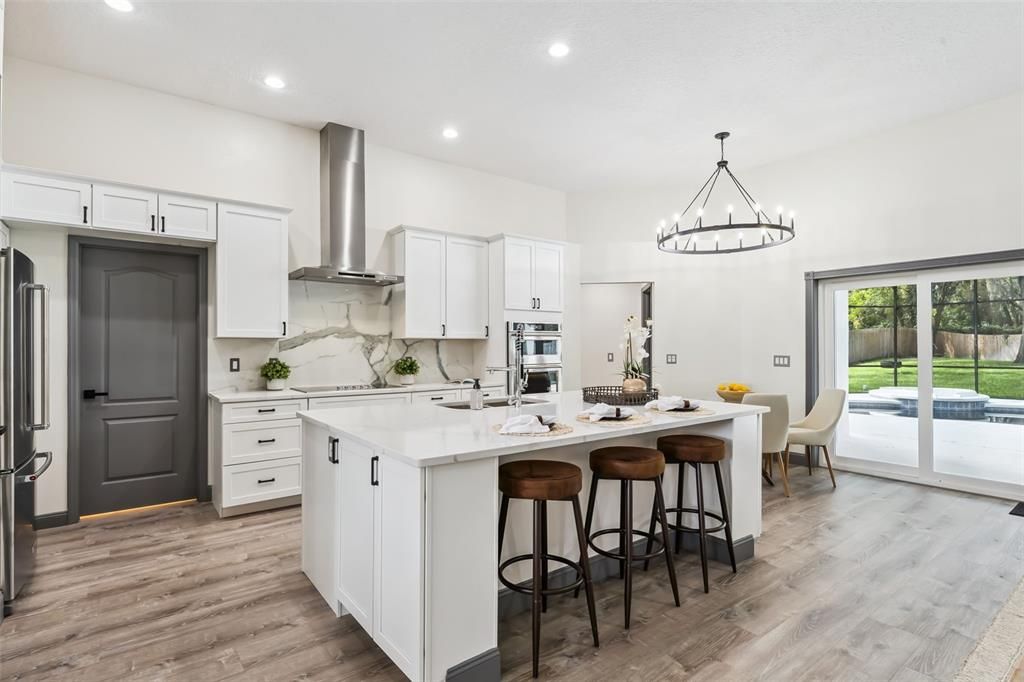 Chandelier, Interior, Kitchen, Marble Walls, Pendant Lights, Recessed Lighting, Stainless Steel Appliances, Wood Texture Flooring