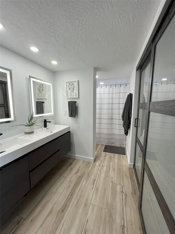 Bathroom, Dual Sink Vanities, Glass Shower, Interior, Recessed Lighting, Wood Texture Flooring