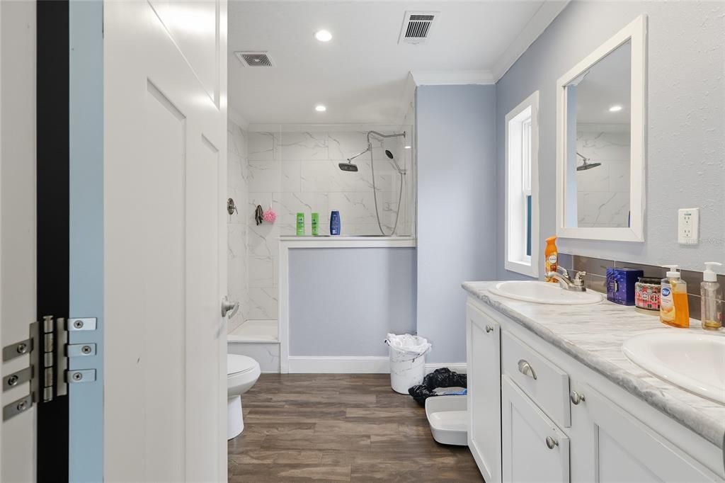 Bathroom, Dual Sink Vanities, Interior, Marble Walls, Recessed Lighting, Wood Texture Flooring
