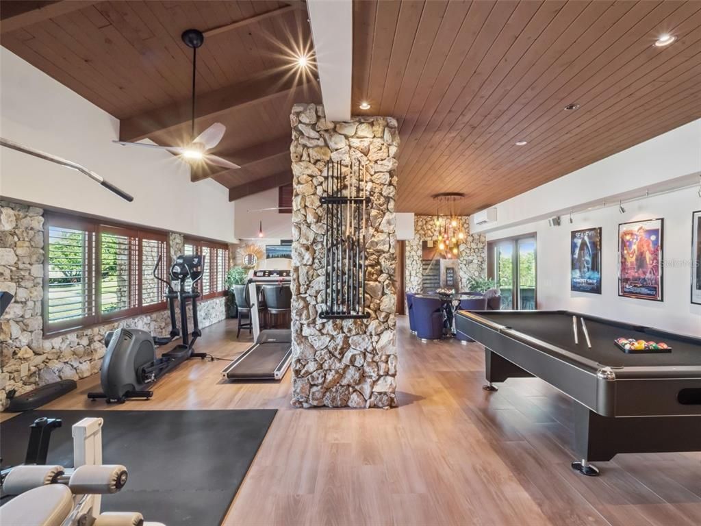 Billiard Table, Chandelier, Fireplace, Fitness Equipment, Game Room, Interior, Recessed Lighting, Stone Walls, Wooden Ceilings, Wood Texture Flooring