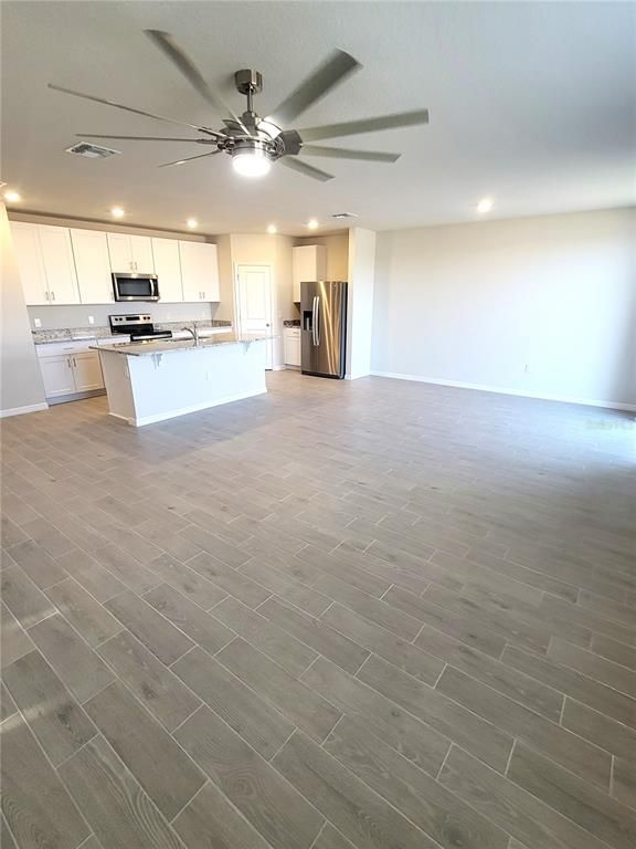 Empty room, Interior, Kitchen, Recessed Lighting, Stainless Steel Appliances, Wood Texture Flooring
