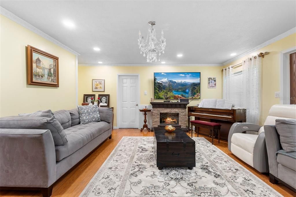 Chandelier, Fireplace, Interior, Living room, Piano, Recessed Lighting, Wood Texture Flooring