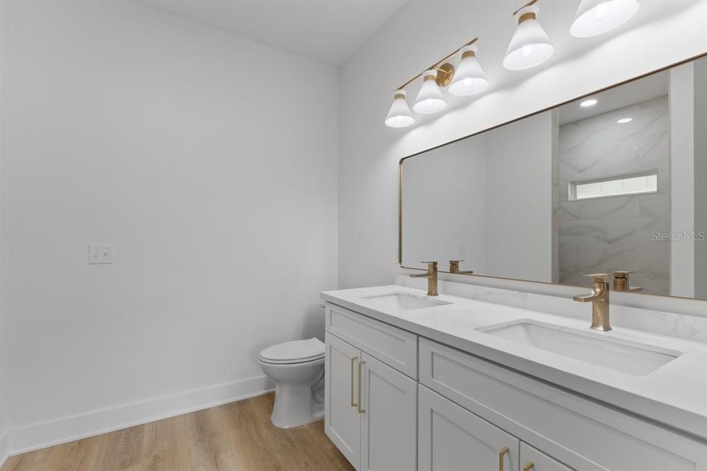 Bathroom, Dual Sink Vanities, Interior, Marble Walls, Recessed Lighting, Wood Texture Flooring