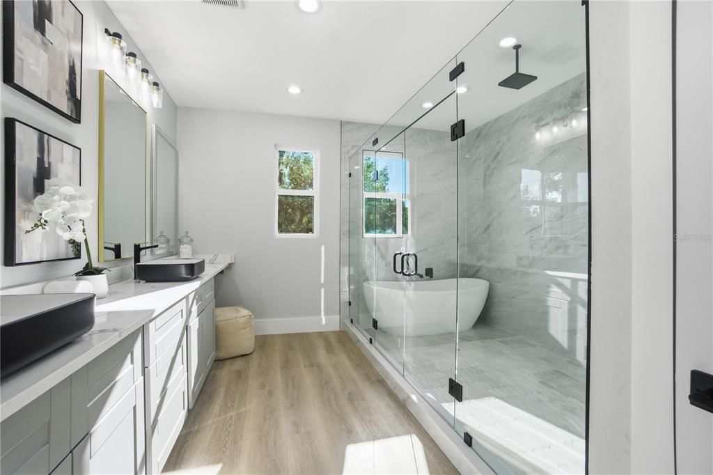 Bathroom, Dual Sink Vanities, Free Standing Baths, Glass Shower, Interior, Marble Walls, Recessed Lighting, Wood Texture Flooring