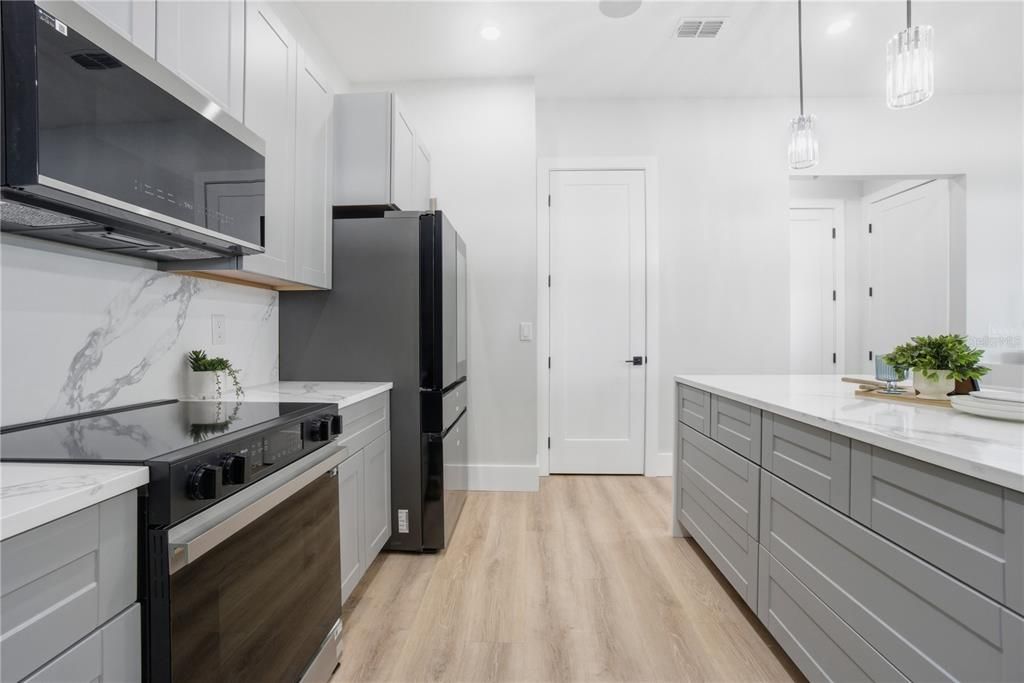 Interior, Kitchen, Marble Walls, Pendant Lights, Recessed Lighting, Stainless Steel Appliances, Wood Texture Flooring