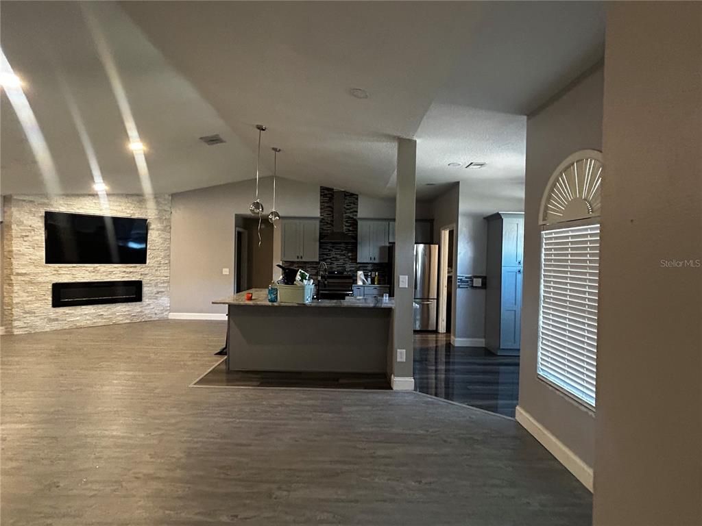 Fireplace, Interior, Kitchen, Pendant Lights, Recessed Lighting, Stainless Steel Appliances, Stone Walls, Wood Texture Flooring