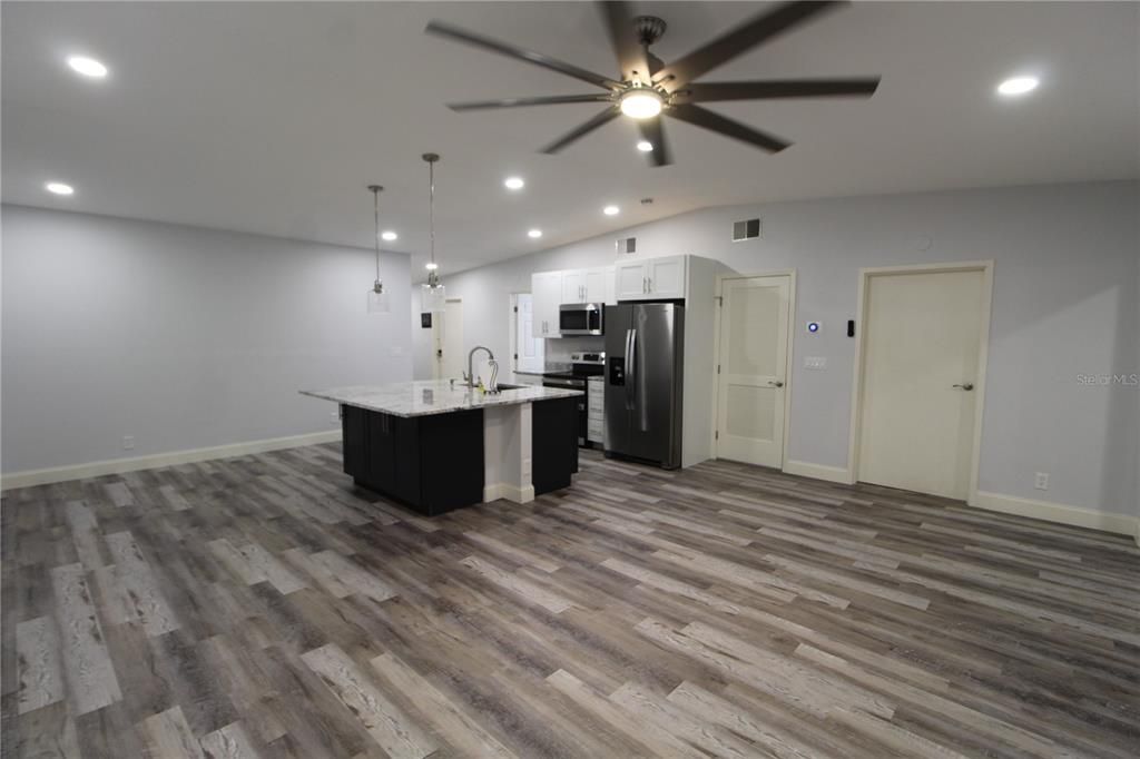 Empty room, Interior, Kitchen, Pendant Lights, Recessed Lighting, Stainless Steel Appliances, Wood Texture Flooring