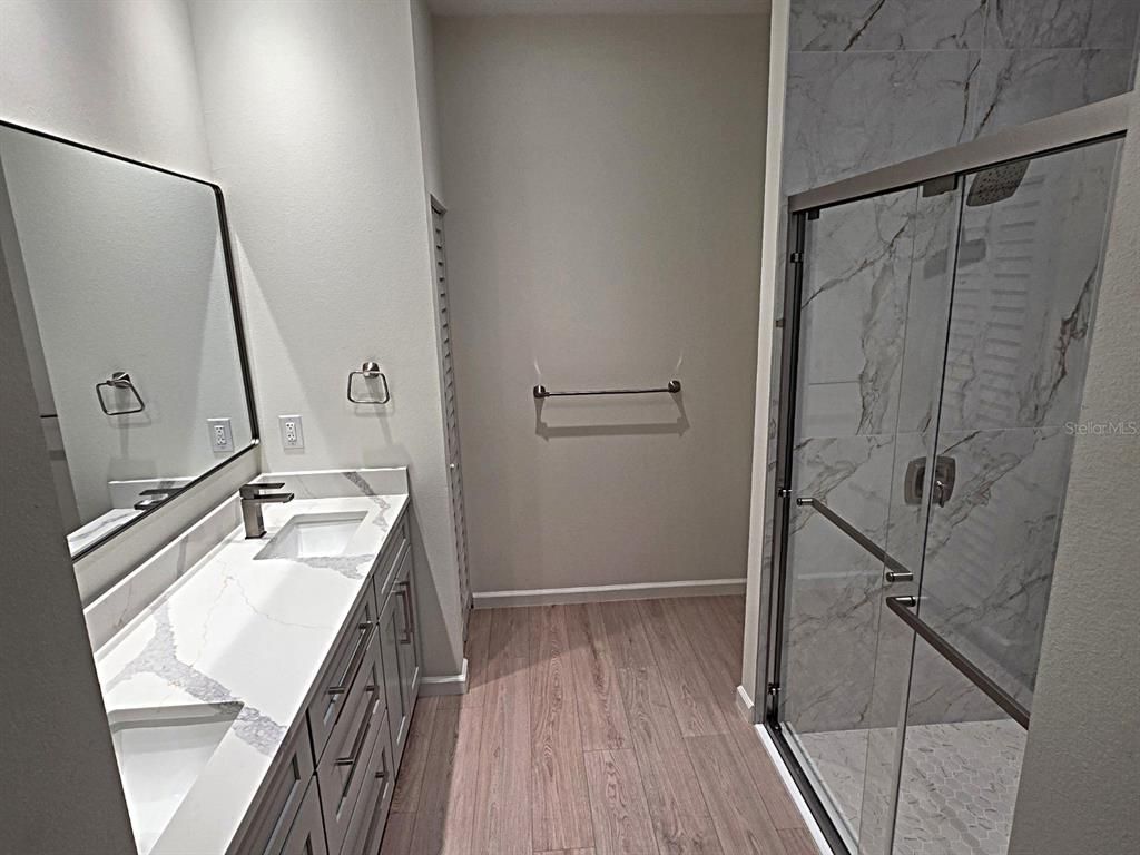 Bathroom, Dual Sink Vanities, Glass Shower, Interior, Marble Walls, Wood Texture Flooring