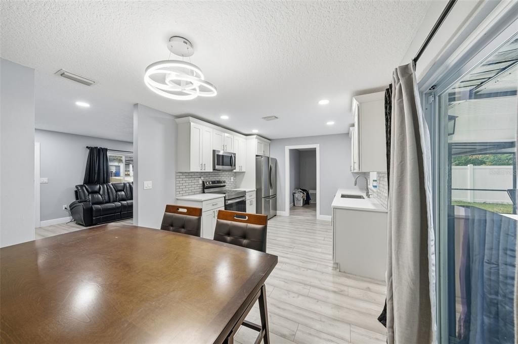 Dining room, Interior, Kitchen, Pendant Lights, Recessed Lighting, Stainless Steel Appliances, Wood Texture Flooring
