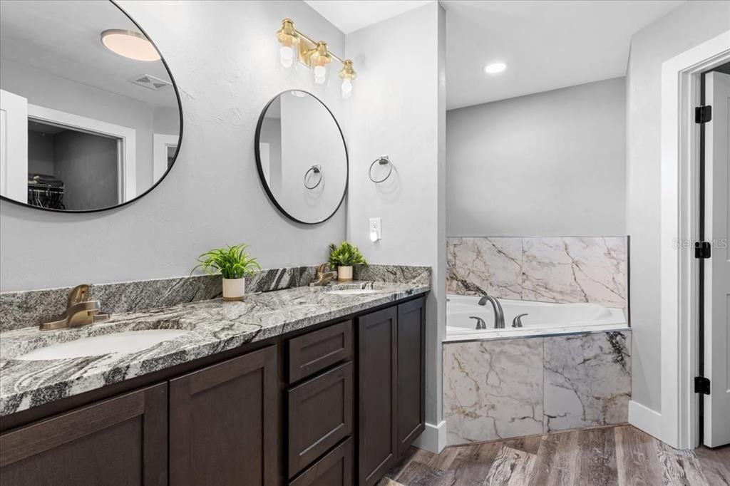Bathroom, Dual Sink Vanities, Interior, Marble Walls, Recessed Lighting, Wood Texture Flooring