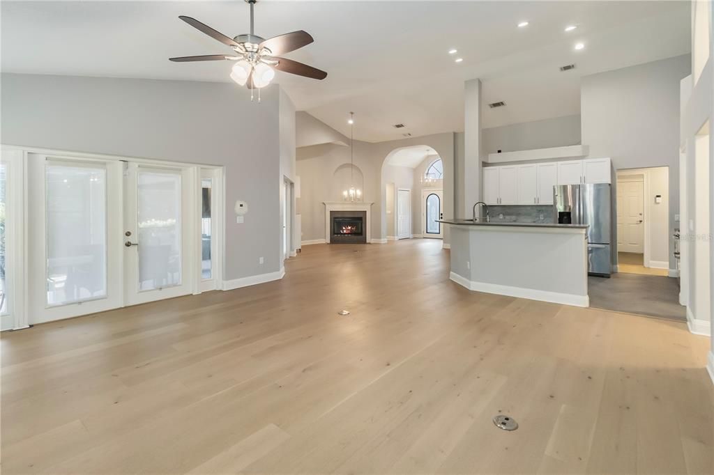 Empty room, Fireplace, Interior, Kitchen, Pendant Lights, Recessed Lighting, Stainless Steel Appliances, Wood Texture Flooring