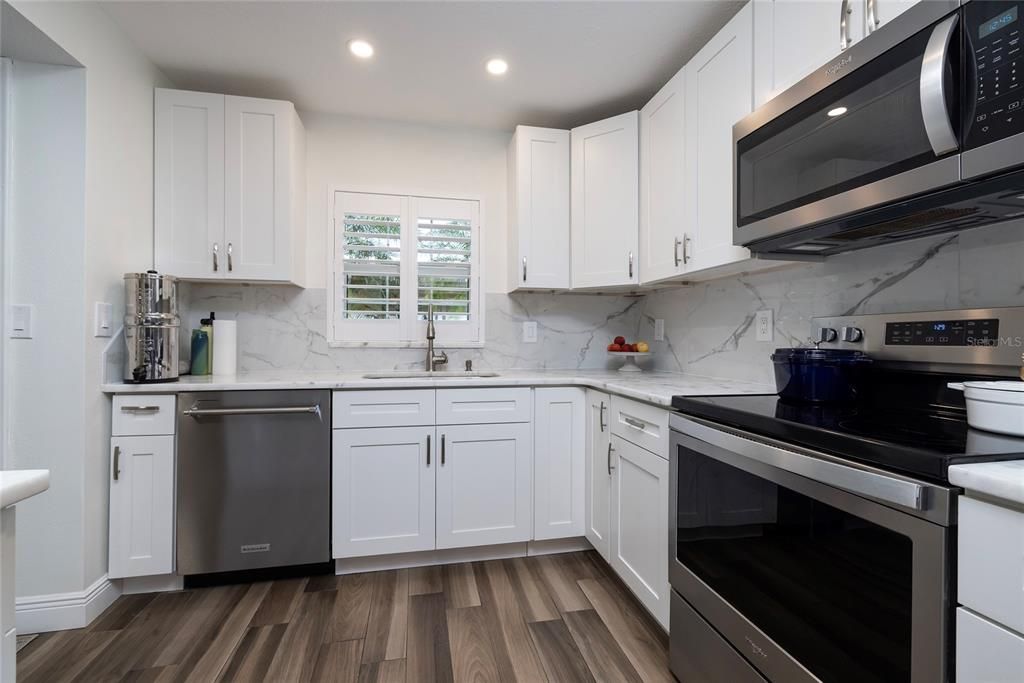 Interior, Kitchen, Marble Walls, Recessed Lighting, Stainless Steel Appliances, Wood Texture Flooring