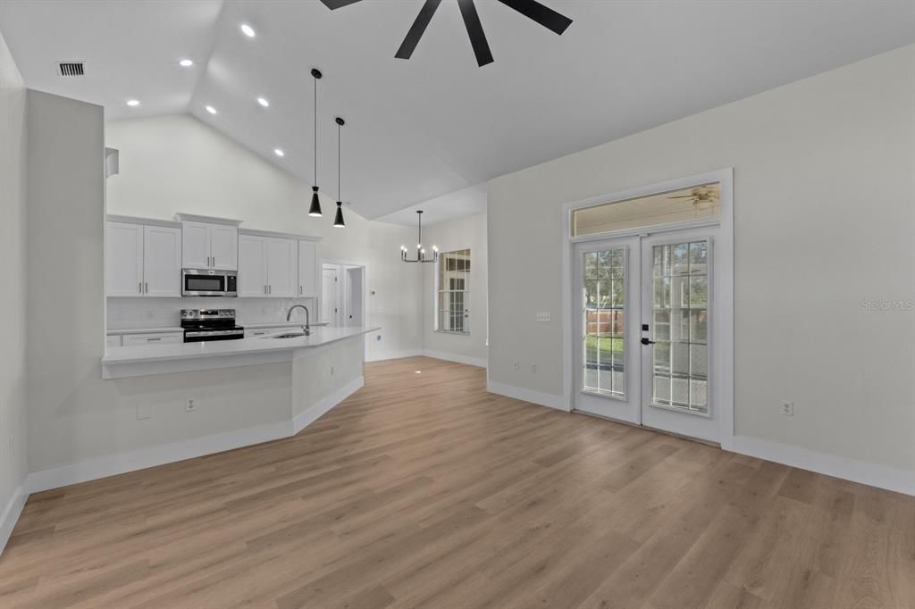 Empty room, Interior, Kitchen, Pendant Lights, Recessed Lighting, Stainless Steel Appliances, Wood Texture Flooring