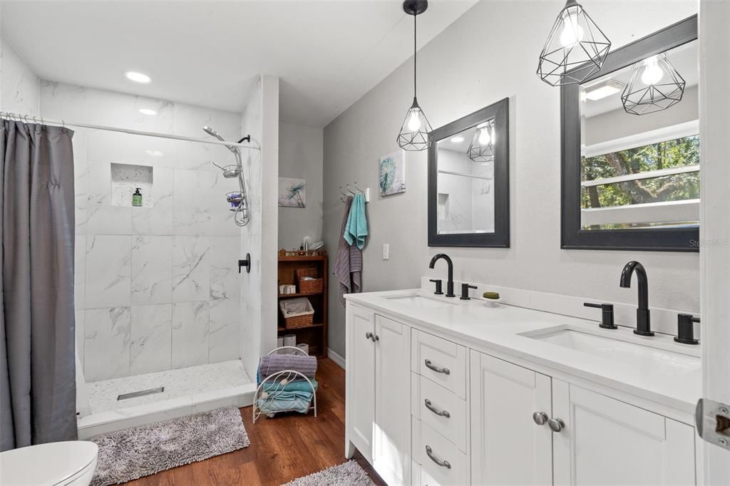 Bathroom, Dual Sink Vanities, Glass Shower, Interior, Marble Walls, Pendant Lights, Recessed Lighting, Wood Texture Flooring