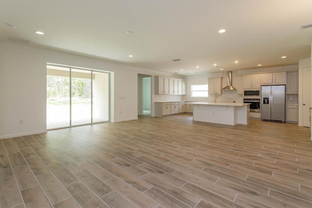 Empty room, Interior, Kitchen, Recessed Lighting, Stainless Steel Appliances, Wood Texture Flooring