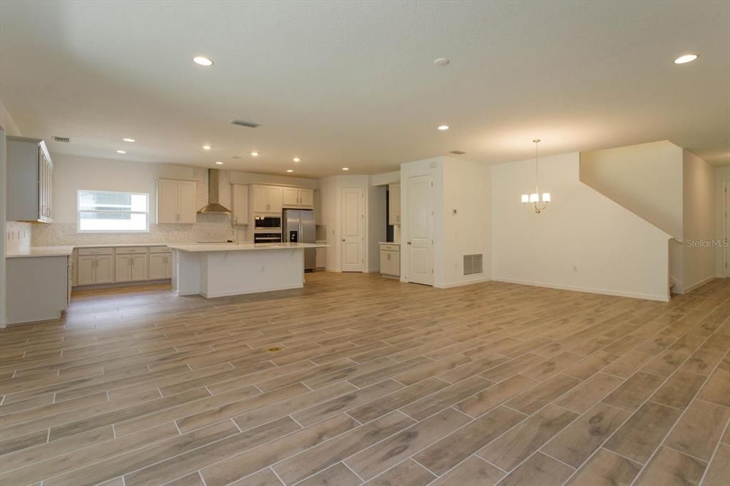 Empty room, Interior, Kitchen, Pendant Lights, Recessed Lighting, Stainless Steel Appliances, Wood Texture Flooring