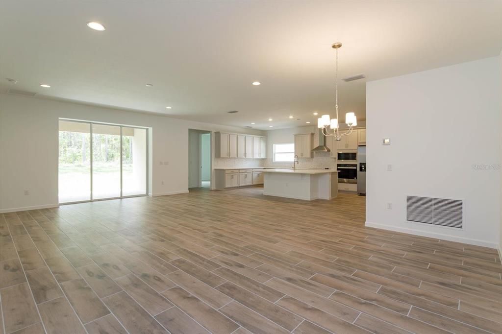 Chandelier, Empty room, Interior, Kitchen, Pendant Lights, Recessed Lighting, Stainless Steel Appliances, Wood Texture Flooring