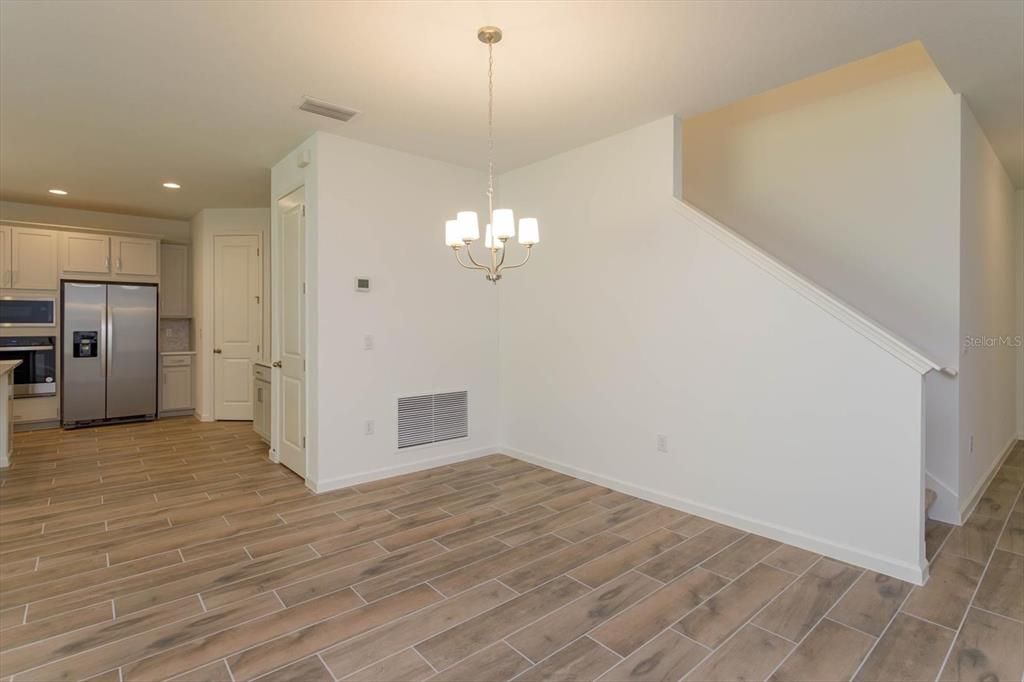 Chandelier, Empty room, Interior, Kitchen, Pendant Lights, Recessed Lighting, Stainless Steel Appliances, Wood Texture Flooring