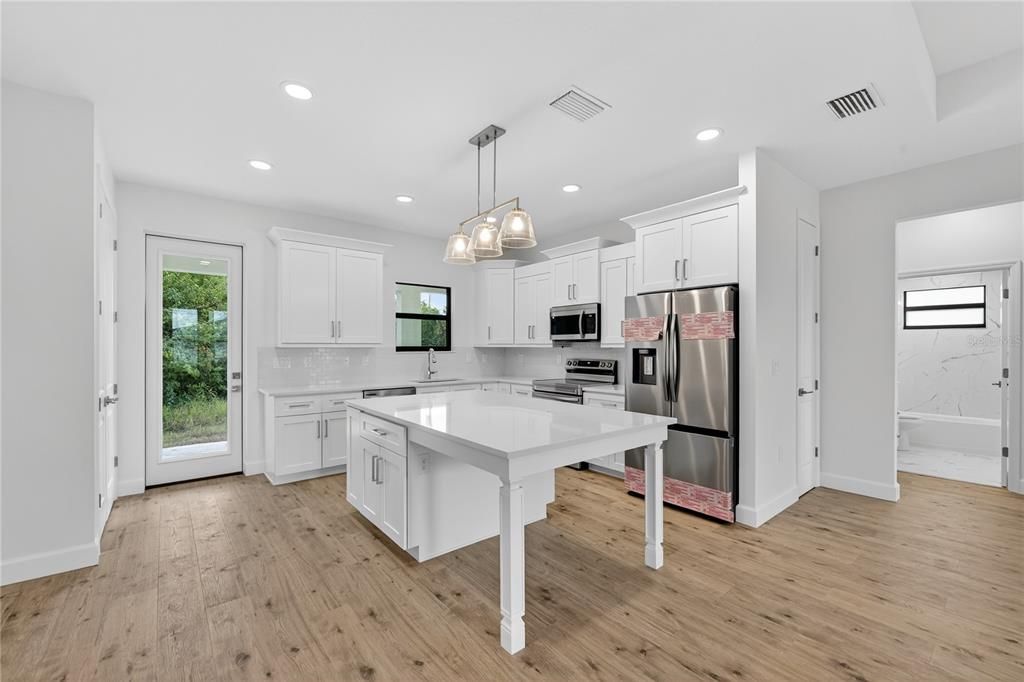 Interior, Kitchen, Marble Walls, Pendant Lights, Recessed Lighting, Stainless Steel Appliances, Wood Texture Flooring