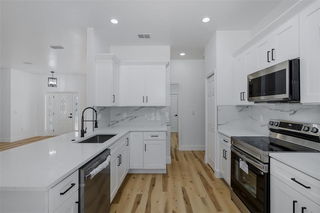 Interior, Kitchen, Marble Walls, Recessed Lighting, Stainless Steel Appliances, Wood Texture Flooring